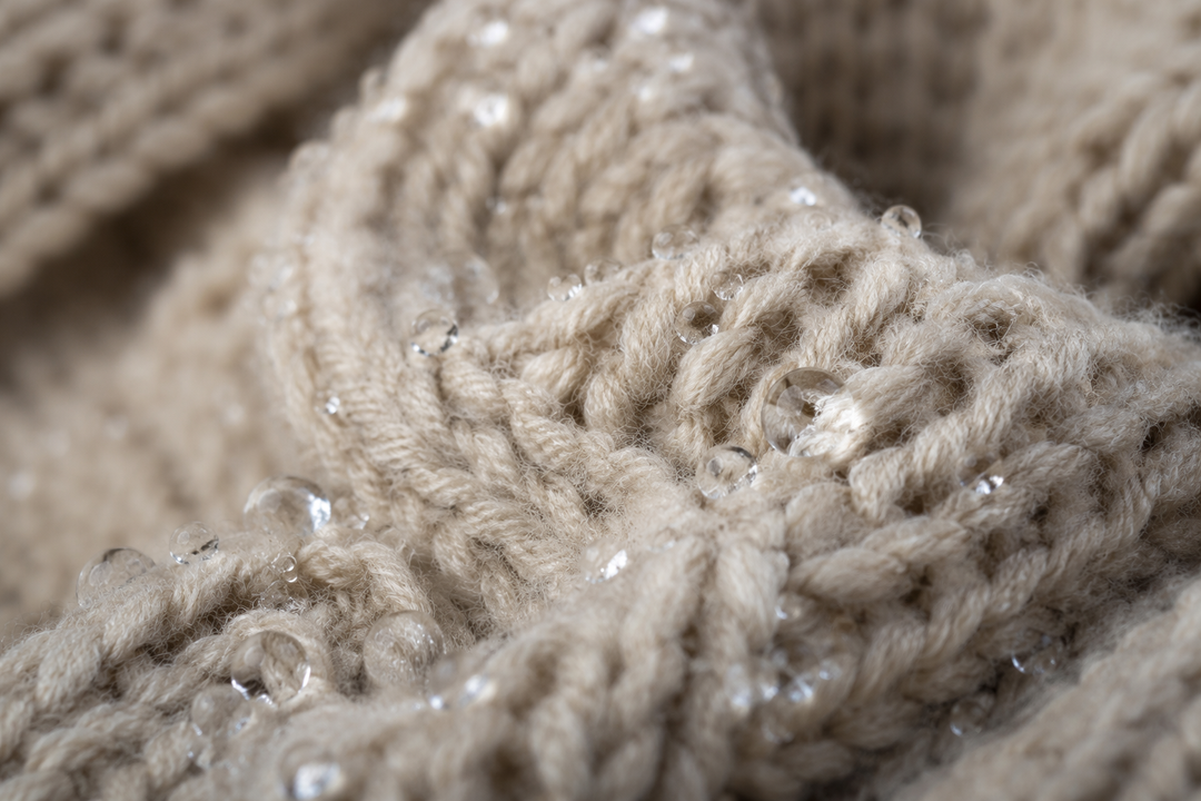 sweater with water droplets beading on yarn surface